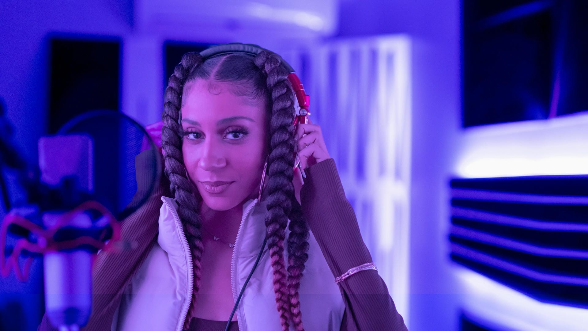 Person with braided hair in a futuristic setting with neon lights
