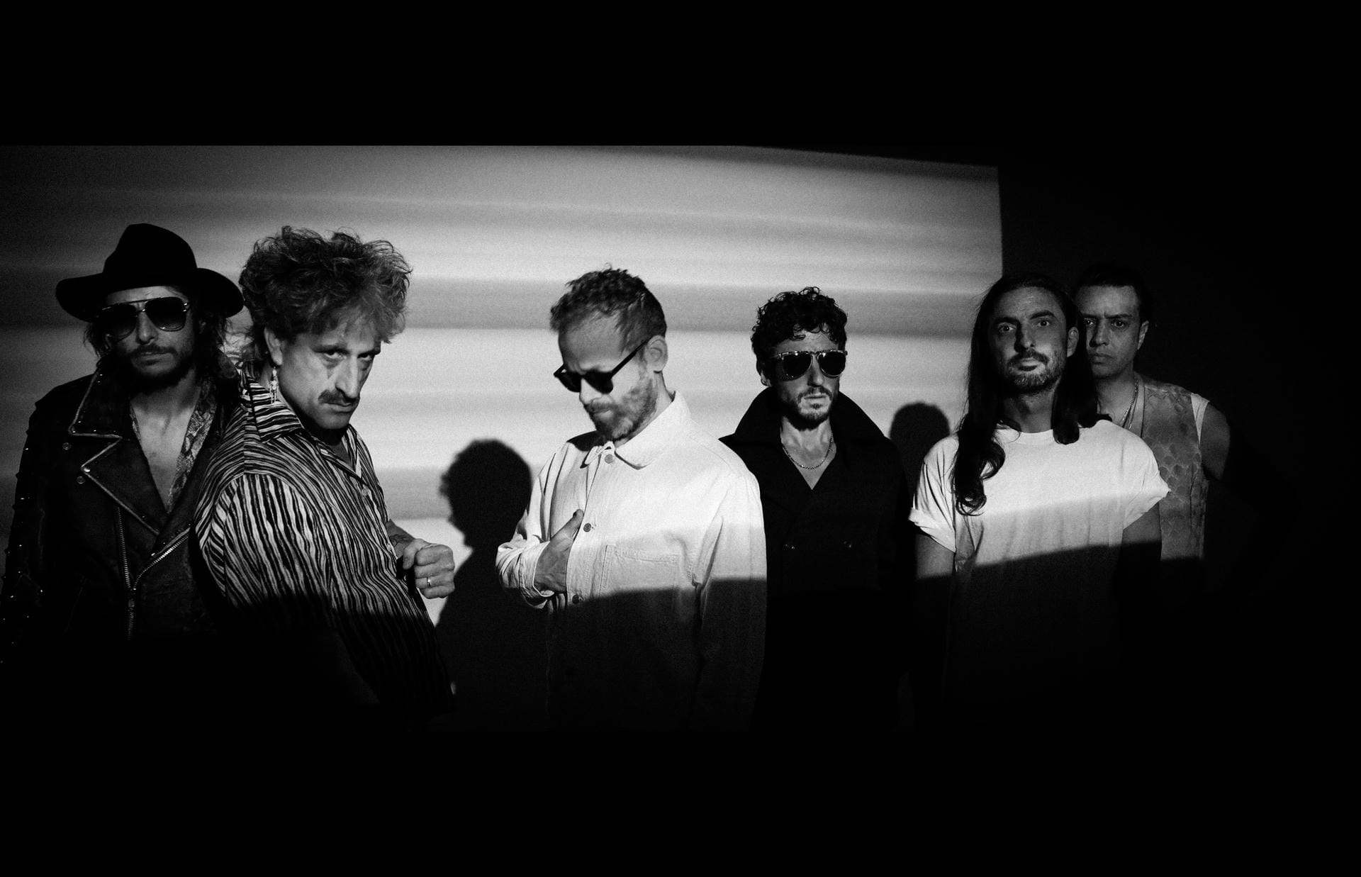 Black and white photo of a group of people standing together with a plain background